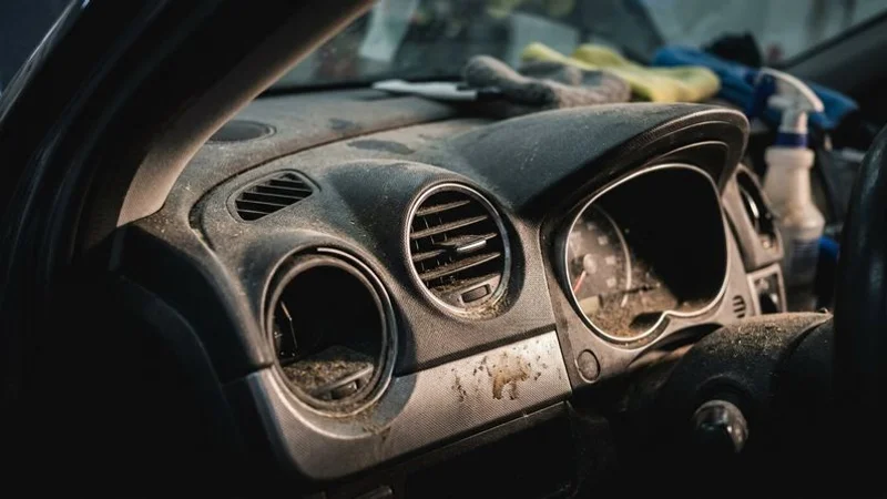 Dusty car dashboard and air vents close up